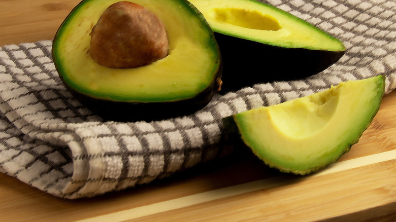 Cut avocados lying on a dish towel.