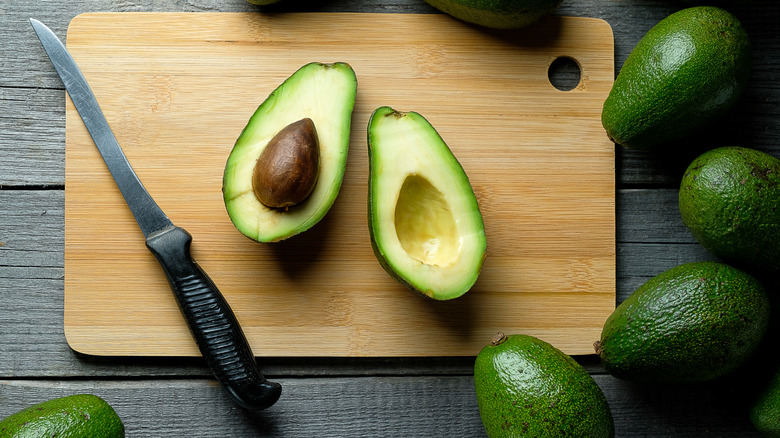 Sliced avocado on a wooden cutting board.