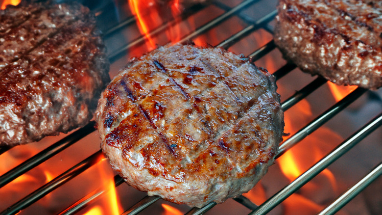 Juicy burger patties cooking on the grill