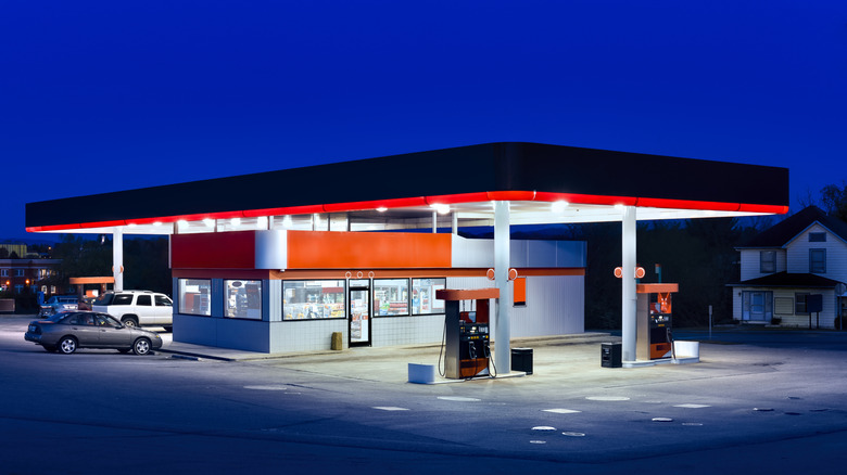 a lit-up gas station with convenience store at dusk