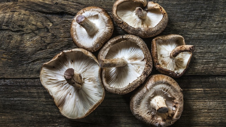 Raw shiitake mushrooms on a wooden surface