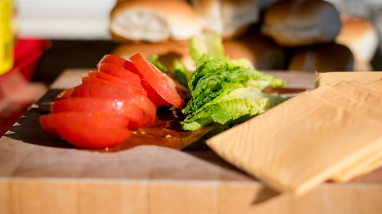 burger toppings on a wooden board