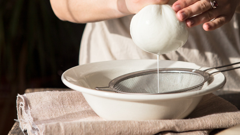 Straining cheese in cheesecloth