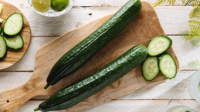 Top view of whole cucumbers on wooden cutting board