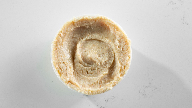 a top-down view of a container of hummus