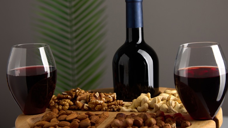 Plater of nuts, bottle and two glasses of red wine