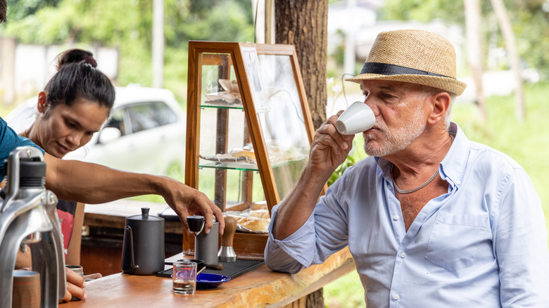 Man drinks espresso at a barista counter