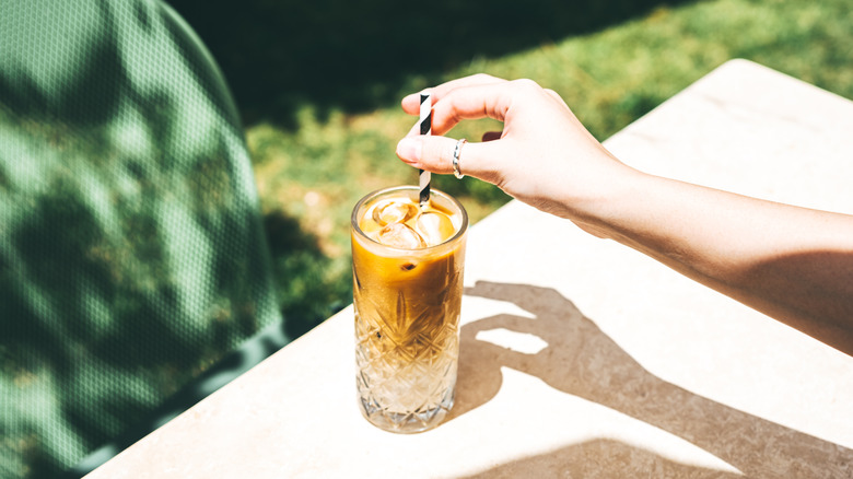 Coffee drinker stirs an iced coffee