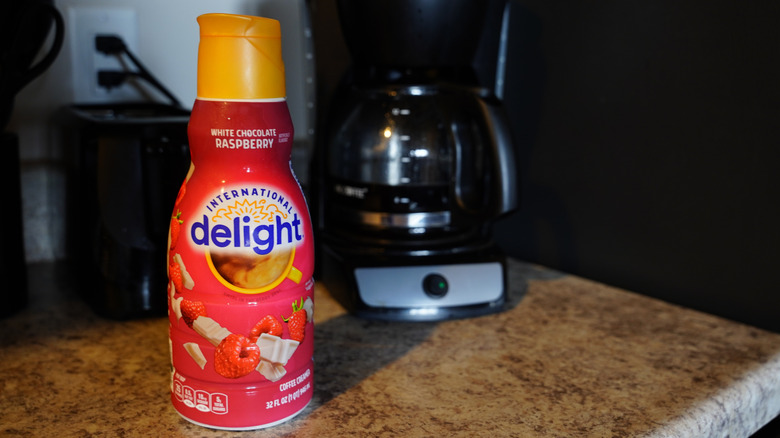 a container of International Delight creamer in the foreground