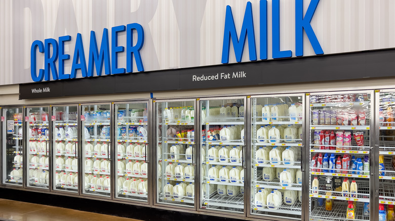 the dairy aisle in a supermarket with coolers that say creamer and milk