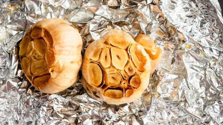 Two heads of roasted garlic on aluminum foil