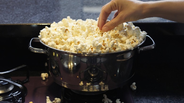 A stainless steel pan full of popcorn.