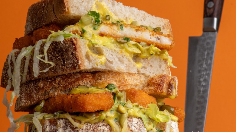 Crispy fish sandwich piled with lettuce and condiments