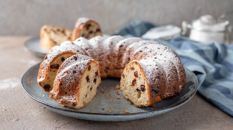 A Bundt cake with crumbs on a plate