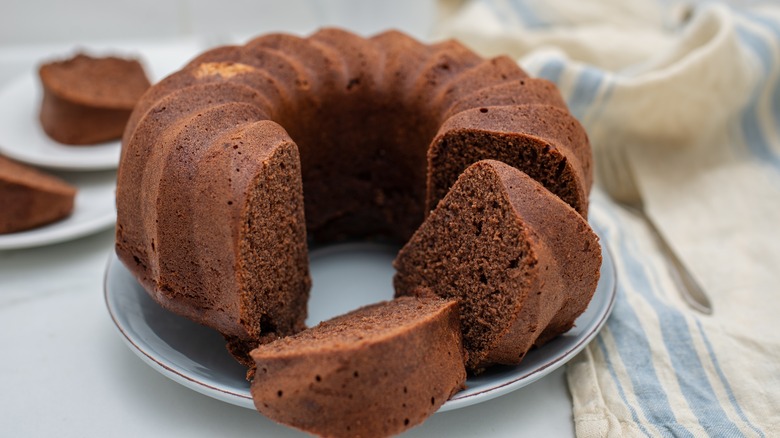 A chocolate Bundt cake is shown in slices on a plate