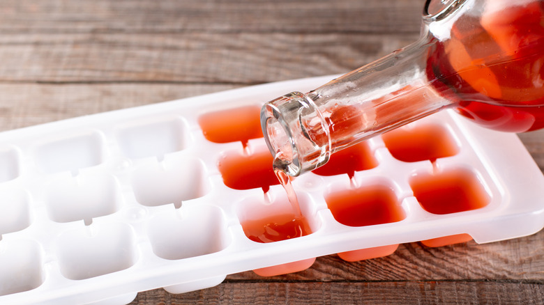 Pouring red wine into ice cube tray