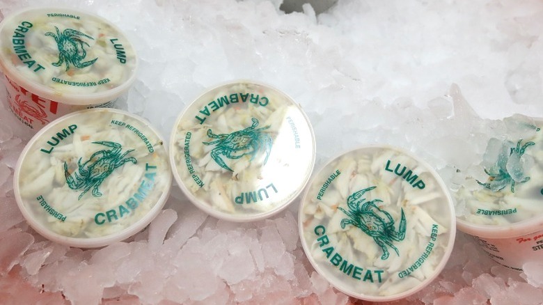 Containers of lump crab meat sitting on ice.