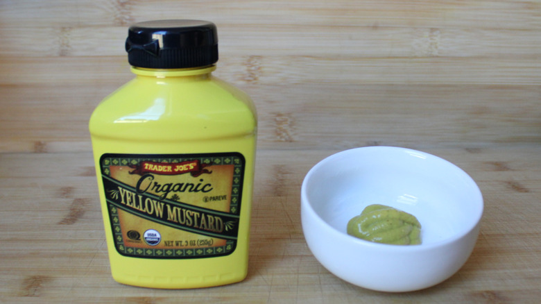 A bottle of Trader Joe's organic yellow mustard on a wood background