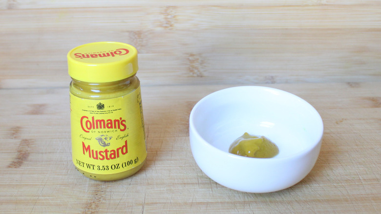 A bottle of Colman's mustard on a wooden background