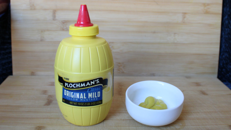 A bottle of Plochman's yellow mustard on a wood background