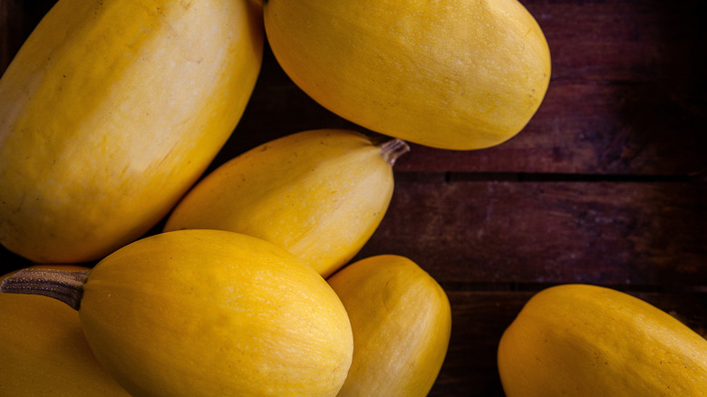 Whole spaghetti squash on a wooden surface