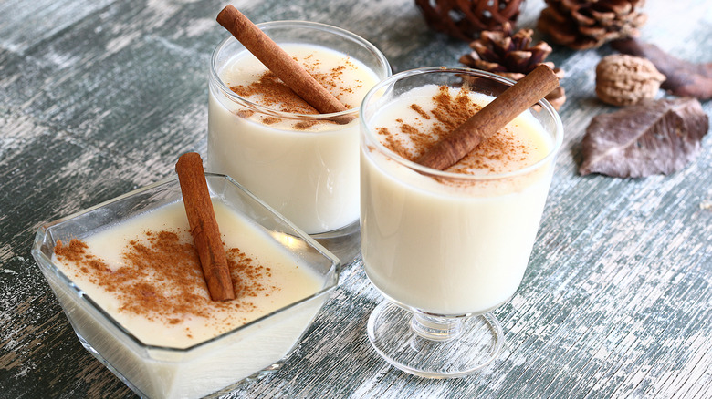 Three glasses of eggnog garnished with cinnamon