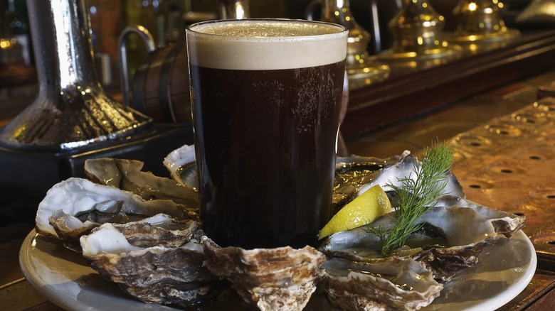 A pint of stout surrounded by oysters.