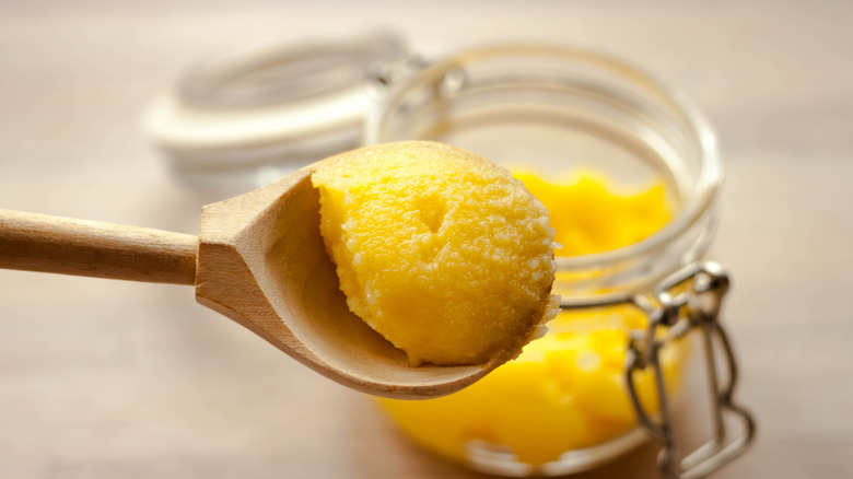 A close-up view of a spoon of clarified butter