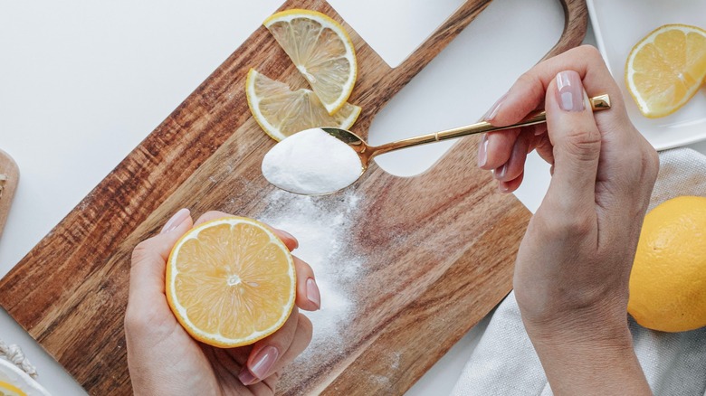 hands washing a wooden cutting board