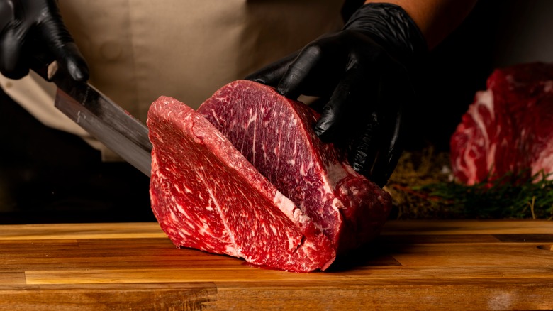 slicing meat on wooden cutting board