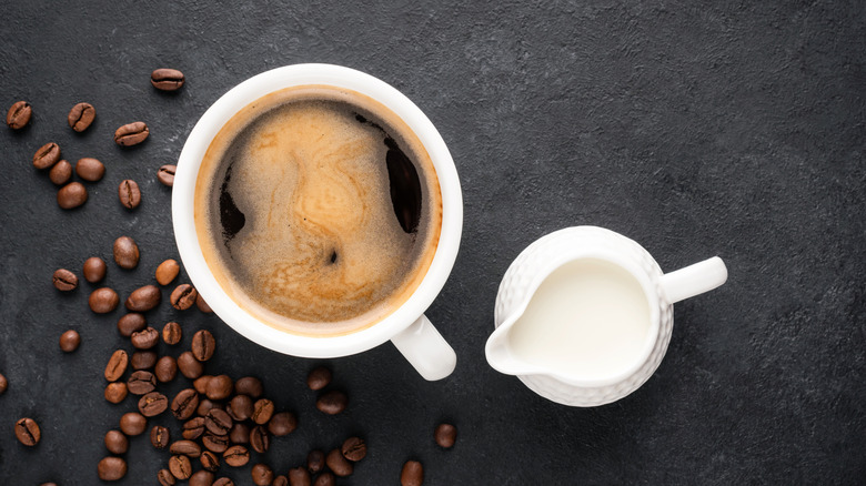 Cup of coffee with jug of creamer