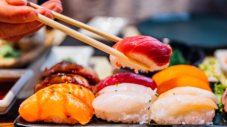 A person using chopsticks to pick up sushi.