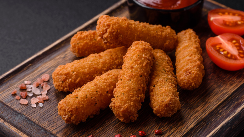 Mozarella sticks on platter with tomatoes and salt