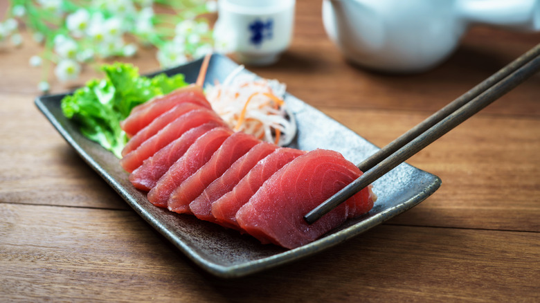 Chopsticks grabbing raw fish