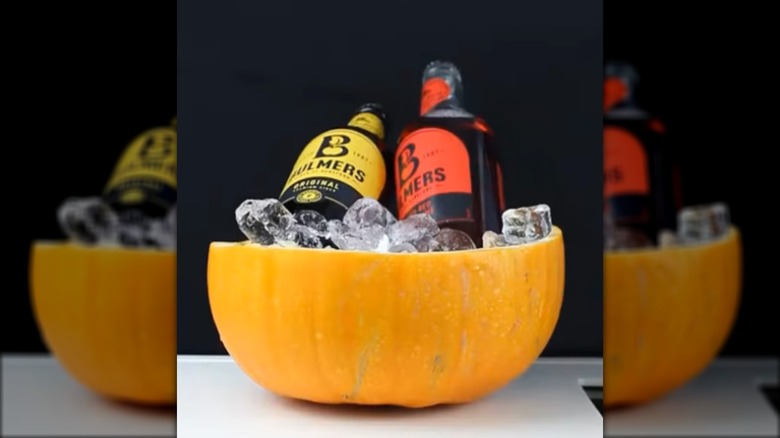 two bottles on ice in a hollowed-out pumpkin