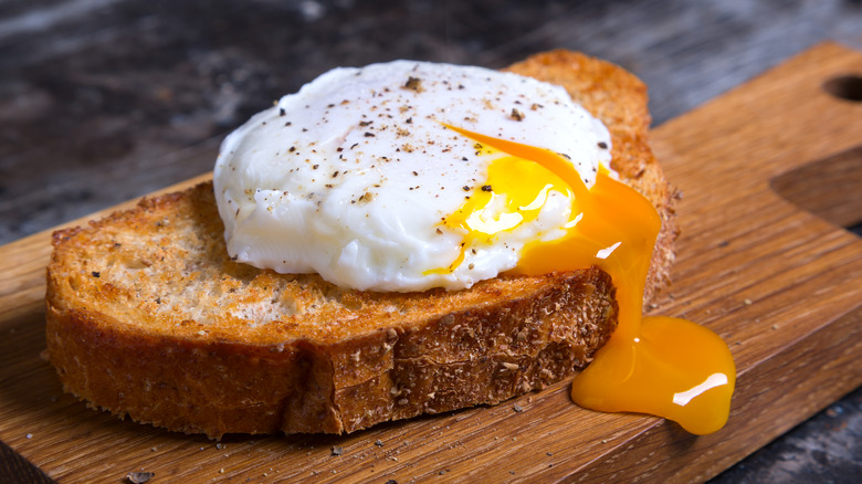 sliced open poached egg on toast