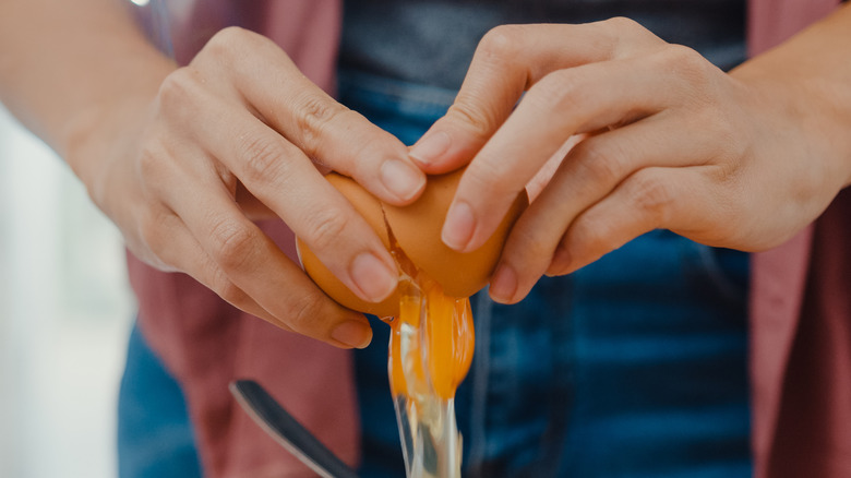 hands cracking egg