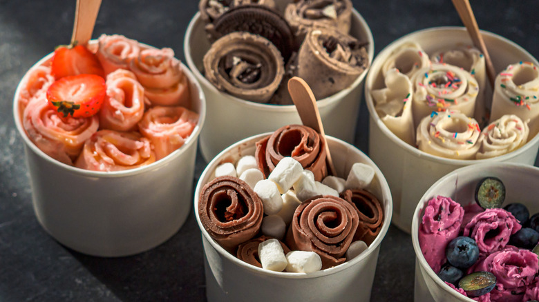 Paper containers of rolled ice cream in various flavors with different toppings