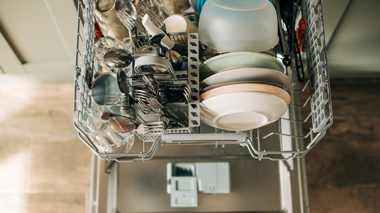 An open dishwasher loaded with dishes