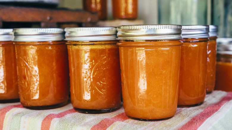 Mason jars full of orange sauce sealed with the lids on