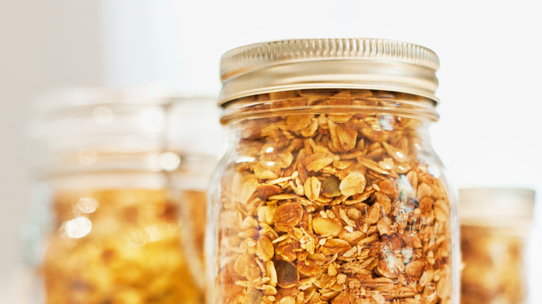 A mason jar full of dry oats with lid and ring on